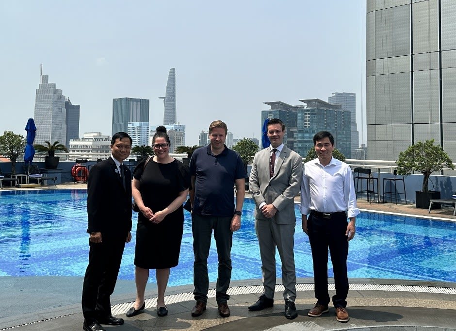 Shayna Osterer, Malcolm Ranta et Giang Pham, diplômés du MBA pour cadres de Telfer, accompagnés de Gabriel Laflamme, délégué commercial, et de Buu Khanh Nguyen, directeur de l’ingénierie de l’hôtel Sofitel, devant l’hôtel Sofitel de la ville de Hô Chi Minh, au Vietnam.
