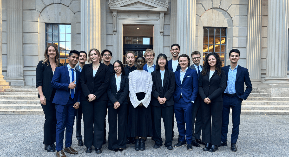 Group of students in business attire standing in front of a building