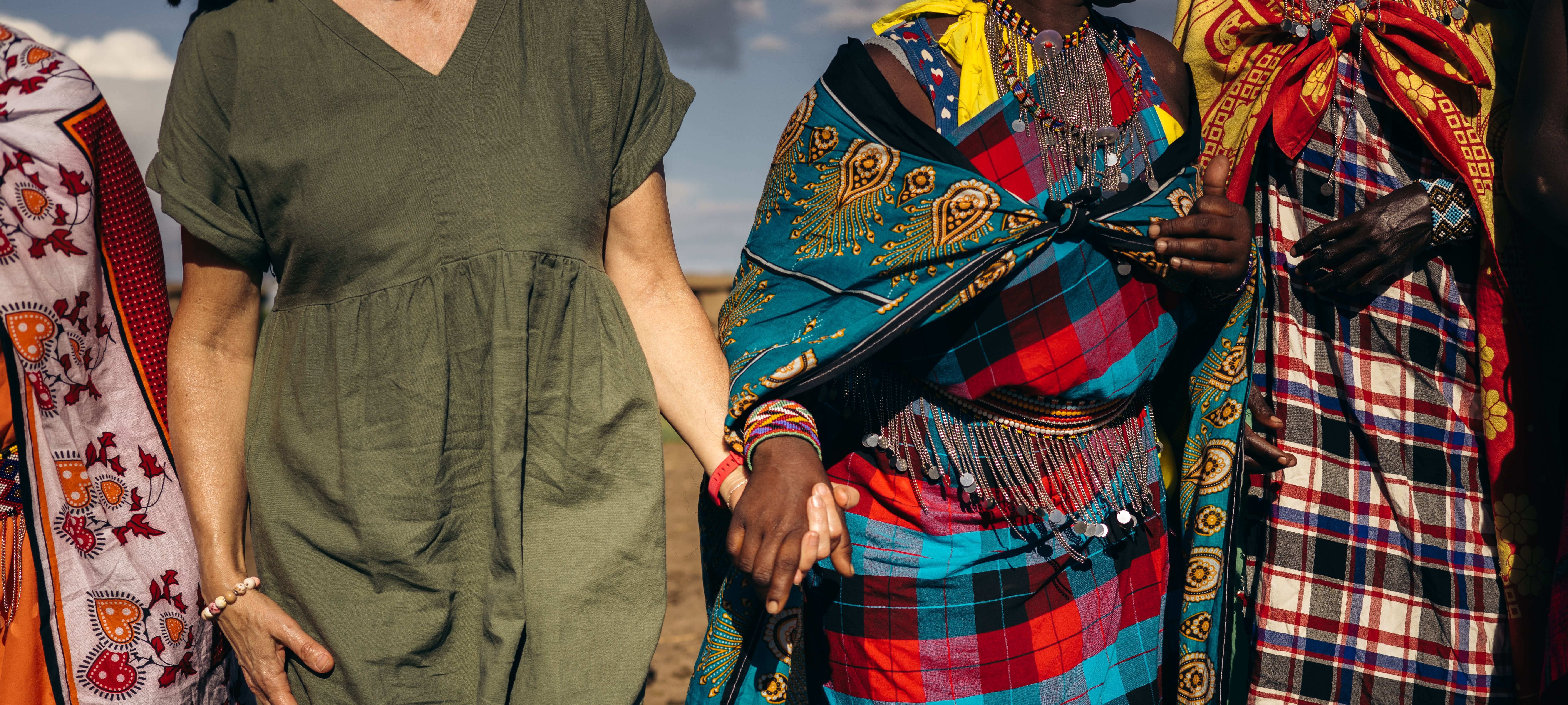 People wearing colourful garments and holding hands