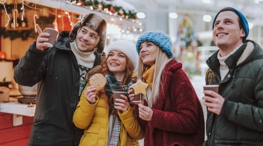 Happy friends enjoying festive treats at the 2024 EU Advent Festival in Zagreb, Croatia.