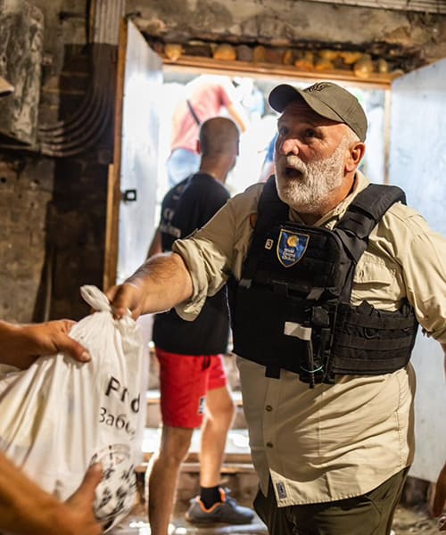 World Central Kitchen team member delivering emergency food relief in a disaster zone, exemplifying frontline humanitarian aid.