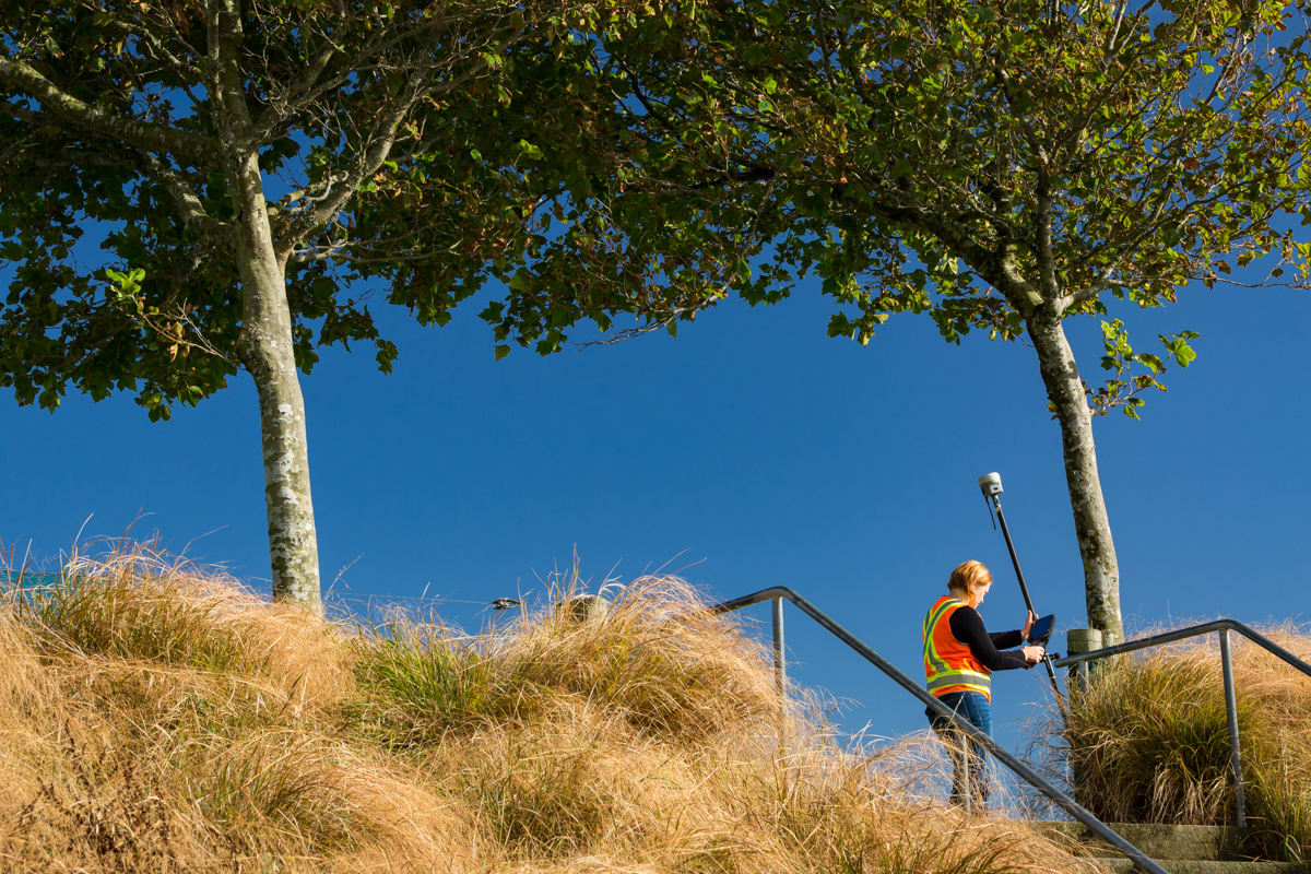 Surveyor using GNSS on a tilted rod in the field
