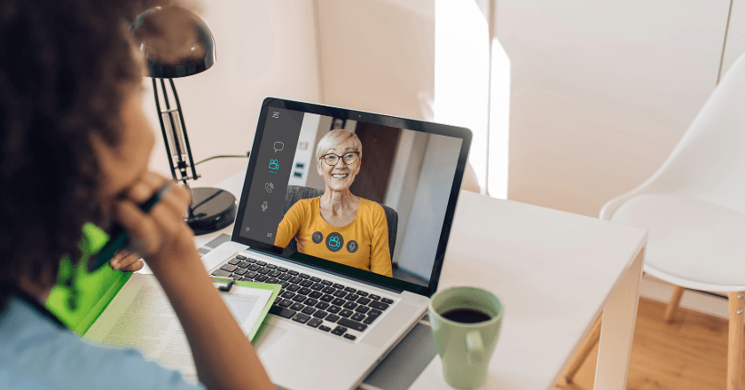 A female clinician conducting a virtual care visit with a female client on her laptop