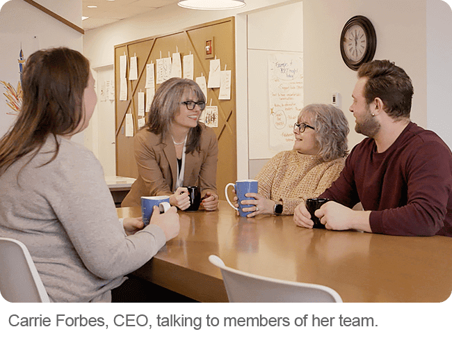 Carrie Forbes, CEO, talking to members of her team.