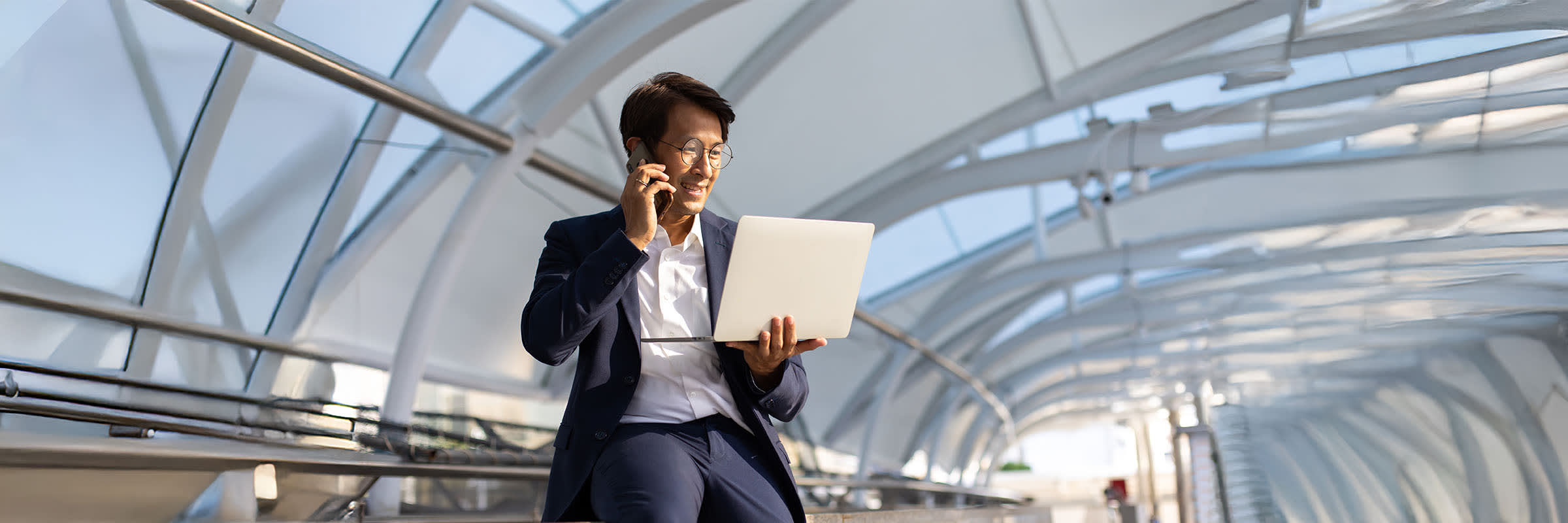 Employé d'entreprise au téléphone et regardant son ordinateur portable pour apprendre comment la solution de protection Harmony Endpoint de Bell propulsé par Check Point utilise une approche axée sur la prévention pour se défendre contre les menaces émergentes. 