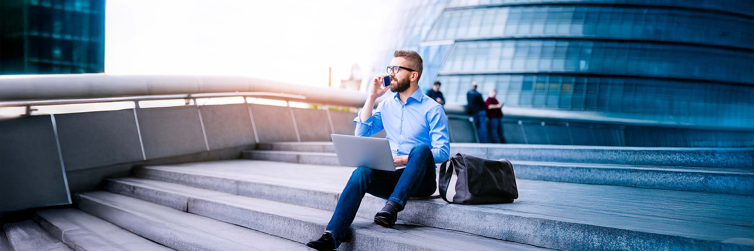 Un homme collabore avec Microsoft Teams à l’aide de son téléphone mobile et d’un ordinateur portable.