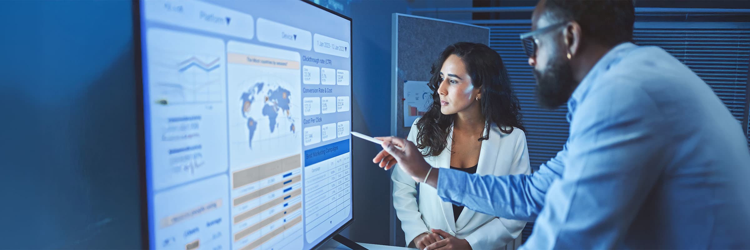 Two cybersecurity professionals examine a Security-as-a-Service (SECaaS) dashboard to confirm data sovereignty – that data remains with Canada and compliant with regulations/regulatory rules.