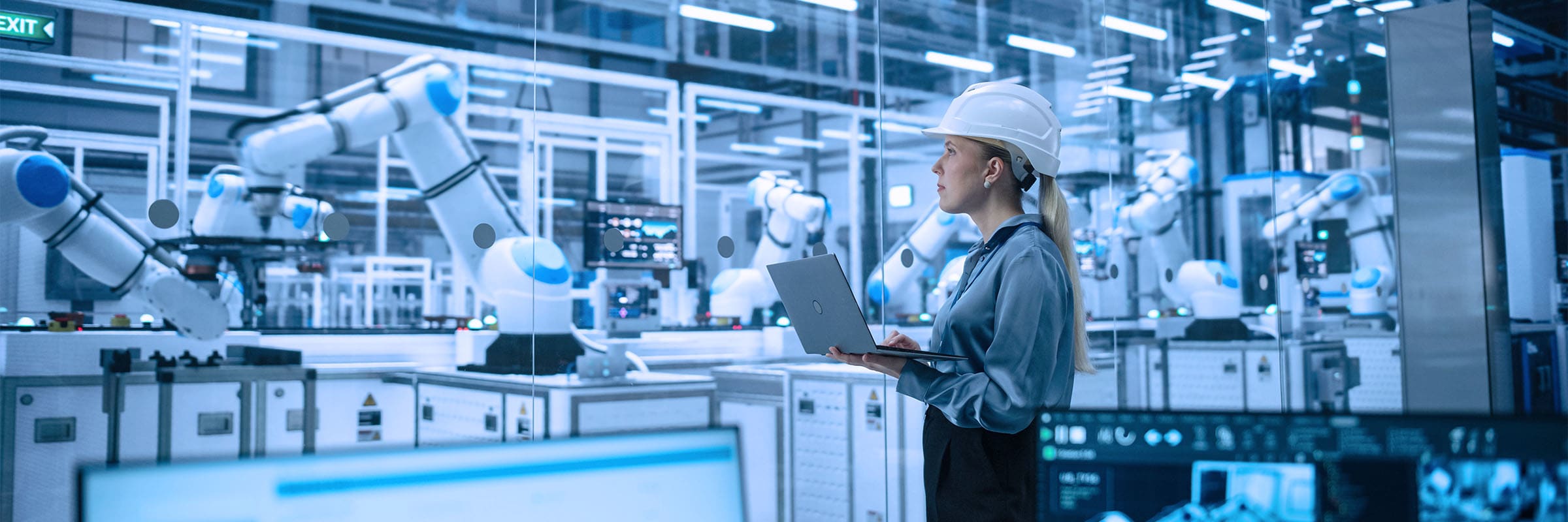 A female engineer oversees a modern, AI-powered manufacturing facility with robotic arms and advanced automation systems.