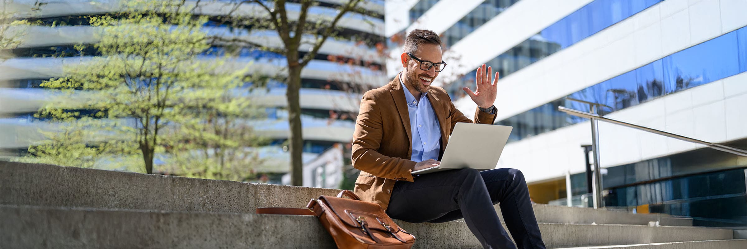 Employee using Workplace from Bell and Zoom sitting on stairs outside the office.