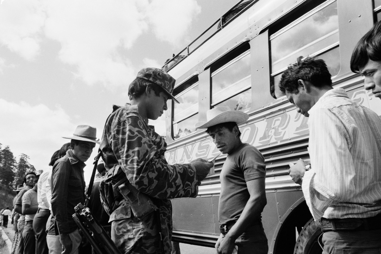 Soldados del Ejército de Guatemala revisan los documentos de identidad de los pasajeros de un autobús que se conducía por la carretera interamericana en Chichicastenango. Guatemala, marzo de 1982. Fotografía de Robert Nickelsberg/GettyImages.