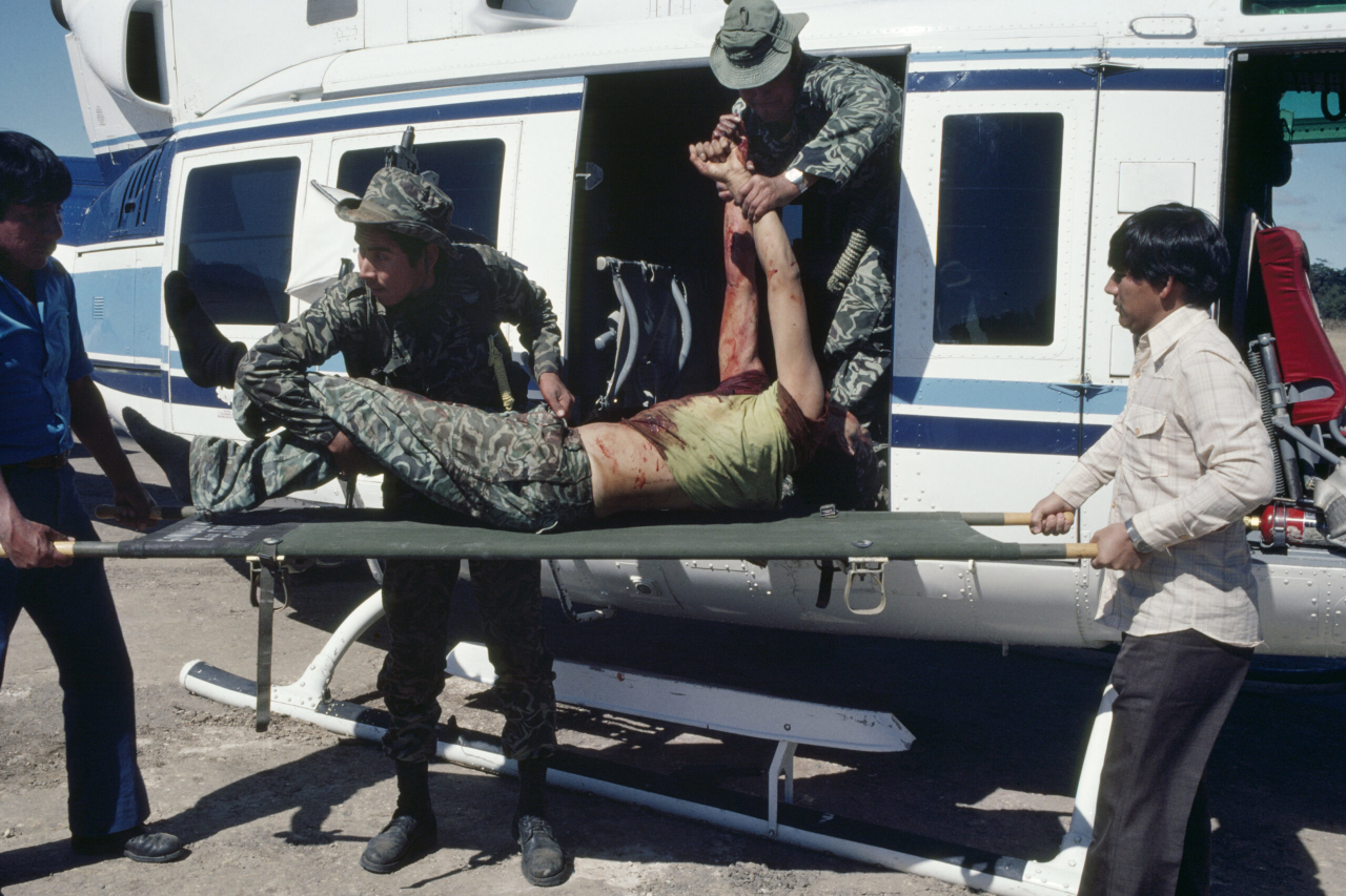 Soldados de las fuerzas armadas guatemaltecas aerotransportan, desde una base militar del altiplano central, a un efectivo fallecido en combate con guerrilleros del EGP el día anterior, en Santa Cruz del Quiché. Guatemala, enero de 1982. Fotografía de Robert Nickelsberg/GettyImages.