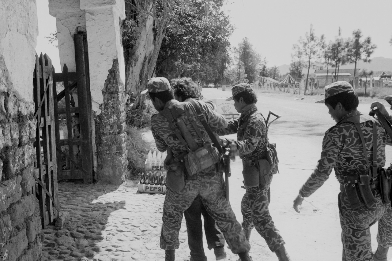 Soldados del Ejército de Guatemala conducen a un presunto guerrillero al interior de la base militar de Santa Cruz del Quiché, para ser interrogado. Guatemala, enero de 1982. Fotografía de Robert Nickelsberg/GettyImages.