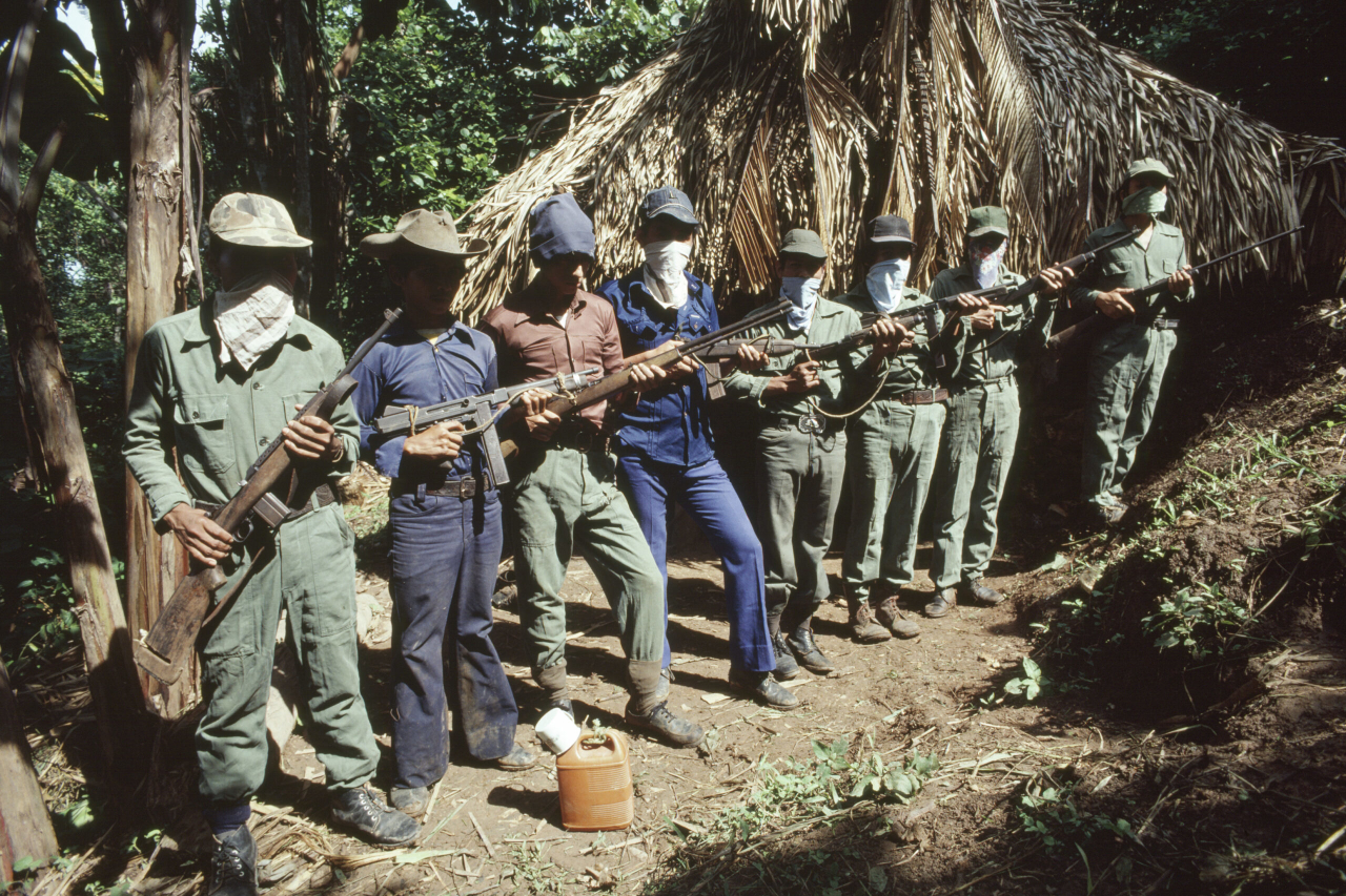 Combatientes del Partido Guatemalteco del Trabajo (PGT) posan junto a sus armas en un campo de entrenamiento cercano a la frontera mexicana, en la región occidental de Guatemala. Guatemala, julio de 1981. Fotografía de Robert Nickelsberg/GettyImages.