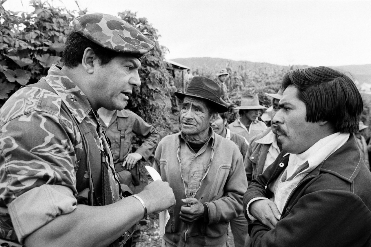 Local residents listen to a Guatemalan army officer, left, speak about forming civil defense patrols to secure their villages against leftist guerrilla attacks near Huehuetenango, Guatemala, mid September 1982. (Photo by Robert Nickelsberg/Getty Images)