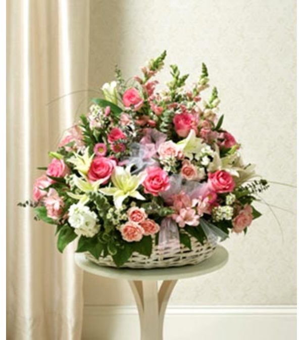Three- Sided arrangement of Assorted pink flowers in basket .