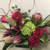 Red roses, protea, and..Artists Choice - Premium. An arrangement by Renton Flower Shop.