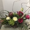 Red roses, protea, and..Artists Choice - Standard. An arrangement by Renton Flower Shop.