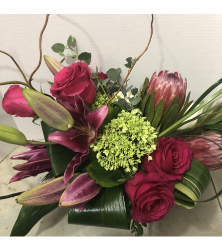 Red roses, protea, and..Artists Choice - Deluxe. An arrangement by Renton Flower Shop.