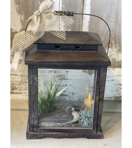 Large Lantern with Wooden Duck and Battery Operated Candle. An arrangement by Metcalfe Florist and Pleasant View Greenhouses.