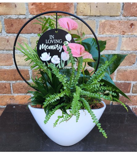 'By Design' In Loving Memory Boat Planter. An arrangement by Flowers By Design.