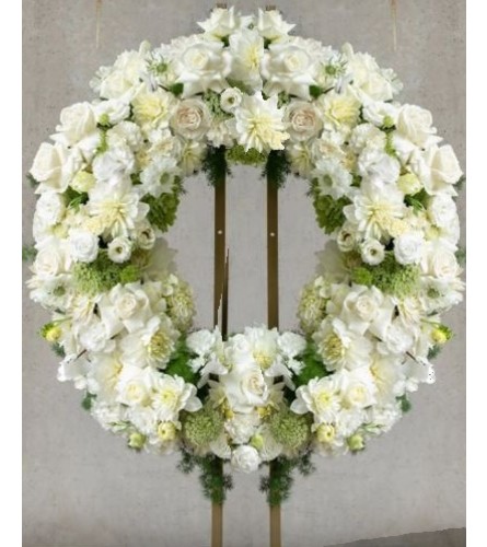 Pure White Wreath - Deluxe. An arrangement by Geni's Florist and Gifts.