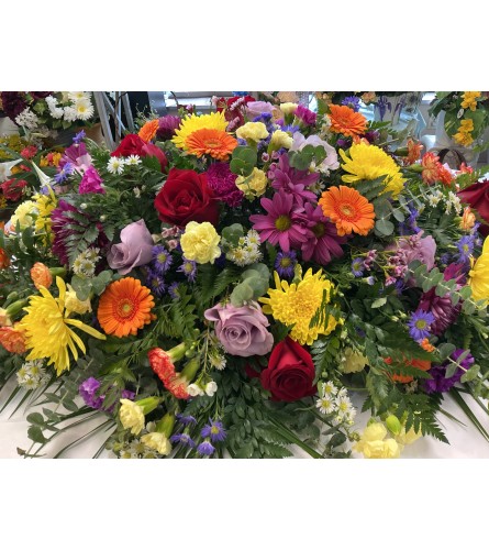 Bright Memories Casket Spray. An arrangement by Roma Flowers and Gifts.