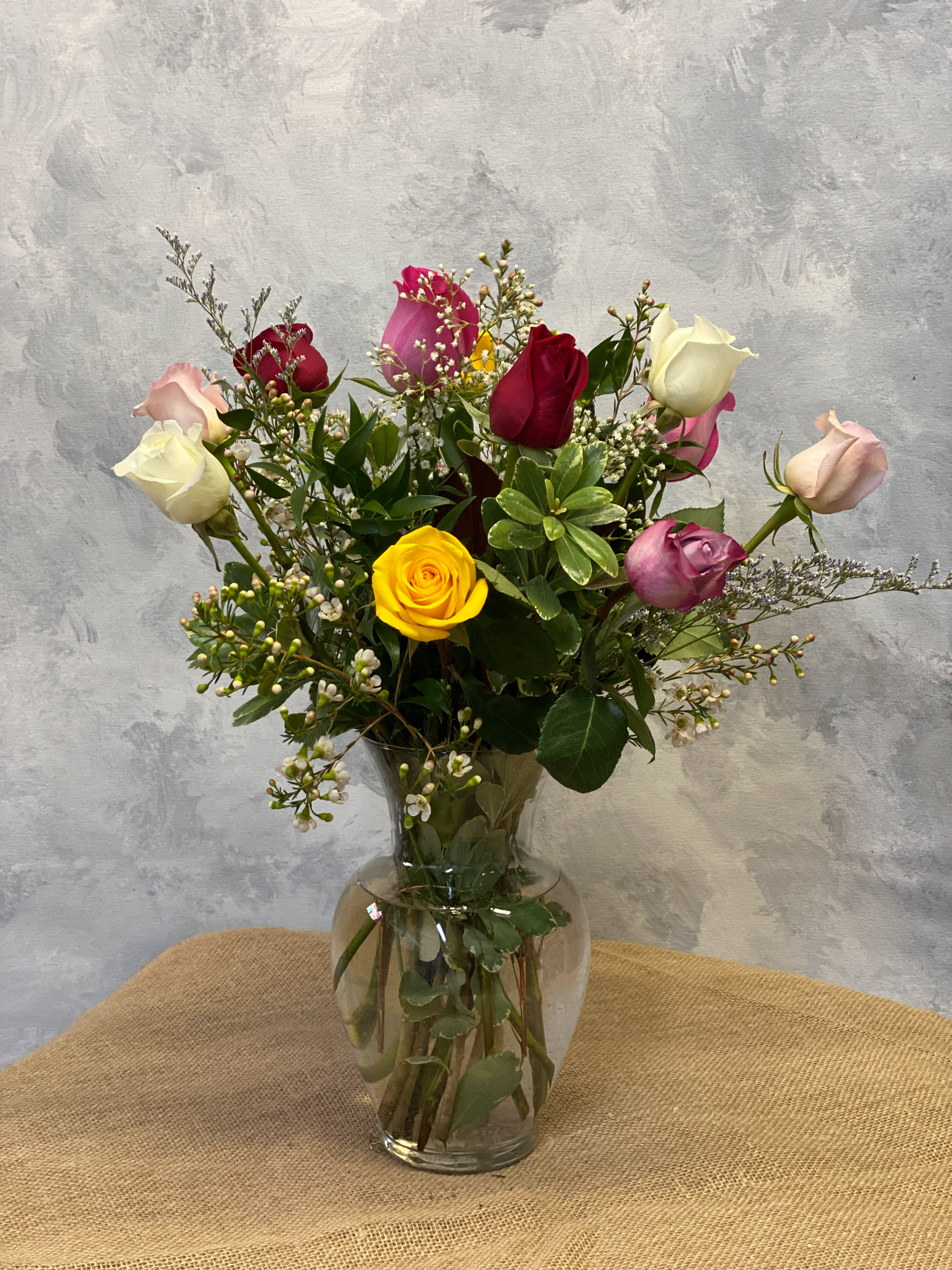 Dozen Assorted Roses. An arrangement by Masters and Company Florist.