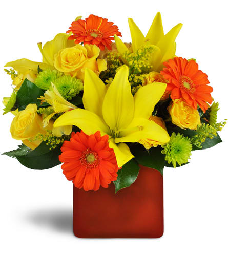 Summer Splash™. An arrangement by A Touch of Class Flowers and Drapery. Orange mini Gebera daisies pop among yellow roses, lilies, and more..