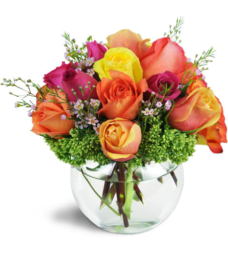 Catch Your Heart™. An arrangement by Masters and Company Florist. More than a dozen colorful roses are arranged with waxflower and sedum in a...