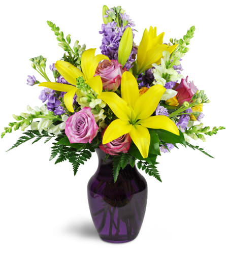 Sprightly Spring™. An arrangement by Hometown Blooms. Yellow Asiatic lilies bloom bright with lavender roses, stock, and creamy white snapdragons...