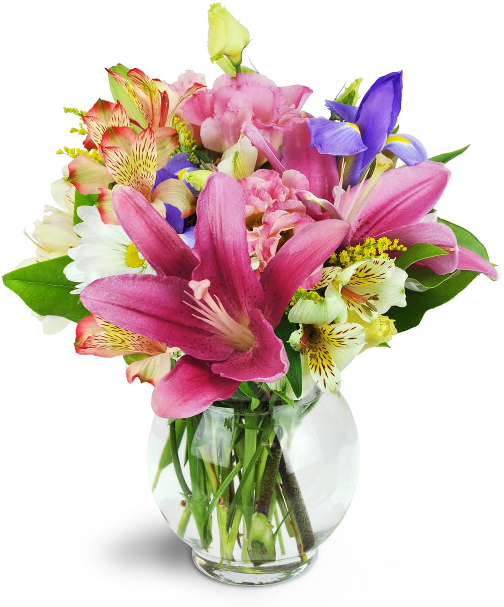 Sweet Symphony™. An arrangement by The Farm and Floral Market. Mauve lilies, blue iris, pink lisianthus, and more are arranged in a fluted bubble...
