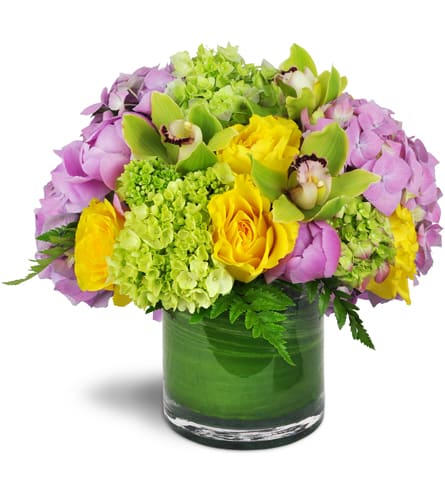 Summer's Bounty Vase™. An arrangement by New Canaan Florist. Green and pink hydrangeas, yellow rose blooms, and distinctive green Cymbidium...