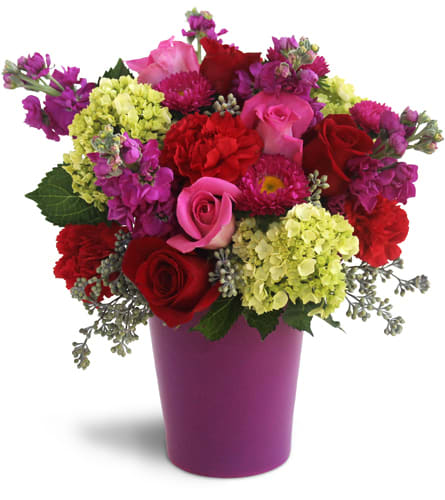 Bursting with Blooms™. An arrangement by The Flower Shop. Pink roses, red roses, red carnations, purple phlox, green hydrangeas, and asters are...
