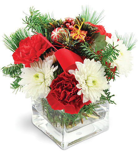 Home for the Holidays. An arrangement by Colonial Flowers and Gift Shoppe. White mums and deep red carnations are accented with pine, holiday...