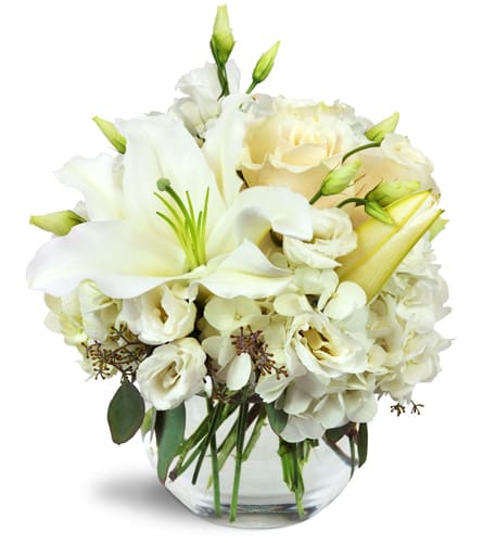Halcyon Heart™. An arrangement by Simpson's Florist. A beautiful all-white arrangement including lilies, roses, lisianthus, and more..