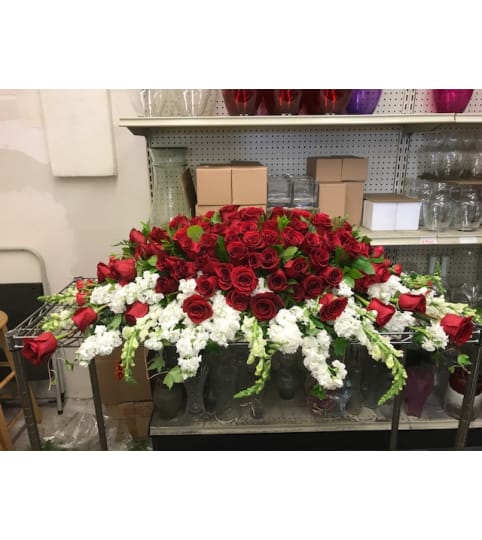 Red roses and carnation on top w/white bottom casket spray no orc