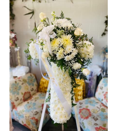 Purity Cross. An arrangement by Geni's Florist and Gifts.
