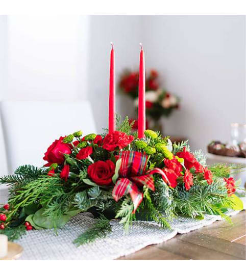By the Candlelight Centerpiece by Conny's Flower Shop. An arrangement by Conny's Flower Shop.