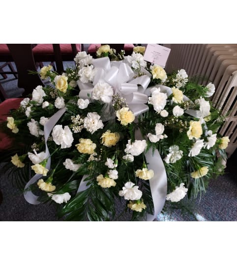 Gentle Lovely Carnation Casket Spray. An arrangement by Flowers By Fiore.