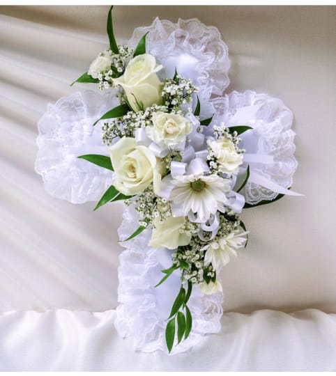 LACE CROSS PILLOW. An arrangement by Brasco Florist.