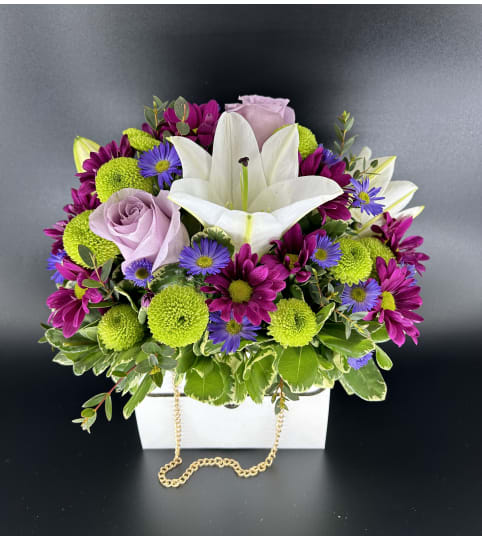 Nothing But Class Purse Arrangement. An arrangement by Hillcrest Florist.