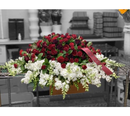 Red carnation and mini red roses on top of white