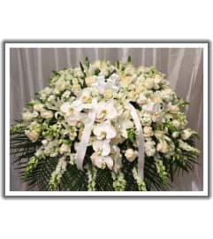 all white casket. An arrangement by Jerome Florist.