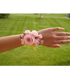 WRIST CORSAGE OF PINK FLOWERS - OR COLOR OF YOUR CHOICE .. An arrangement by Flowers by Priscilla.