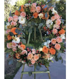 A Sympathy Wreath in Orange/Peace. An arrangement by Seasons Change Designs.