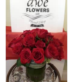 Red roses wrapped in greens. An arrangement by Awe Flowers.
