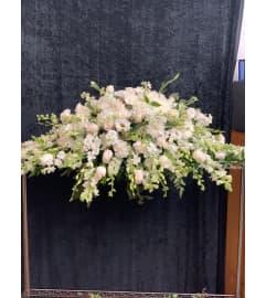 Casket Spray White w/Ivory Roses. An arrangement by Massey's House of Flowers.