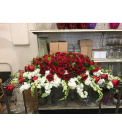 Red roses and carnation on top w/white bottom casket spray no orc. An arrangement by Massey's House of Flowers.