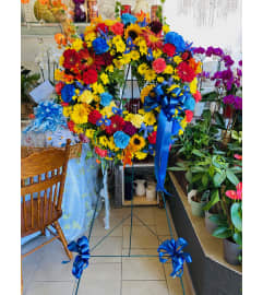 Colorful Celebration Sympathy Wreath. An arrangement by Sonia's Florist.