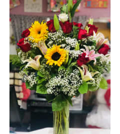 RED ROSES AND SUNFLOWERS. An arrangement by Geni's Florist and Gifts.